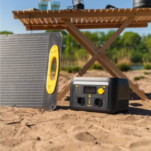Panneau solaire portable et générateur compact sur sable avec poignée jaune, près d’une table de camping en plein air.